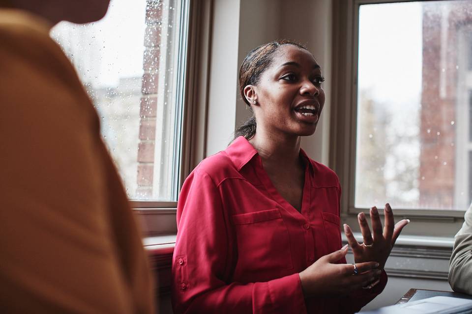 graduate students discuss a class project in a small group