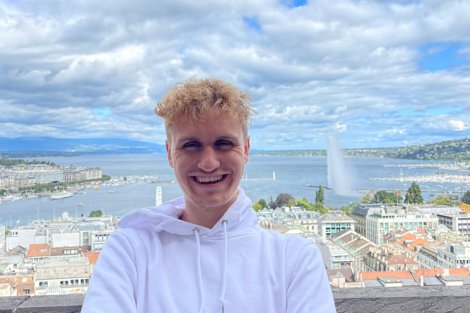 Snapshot of Will Arras with a backdrop of a city and harbor.