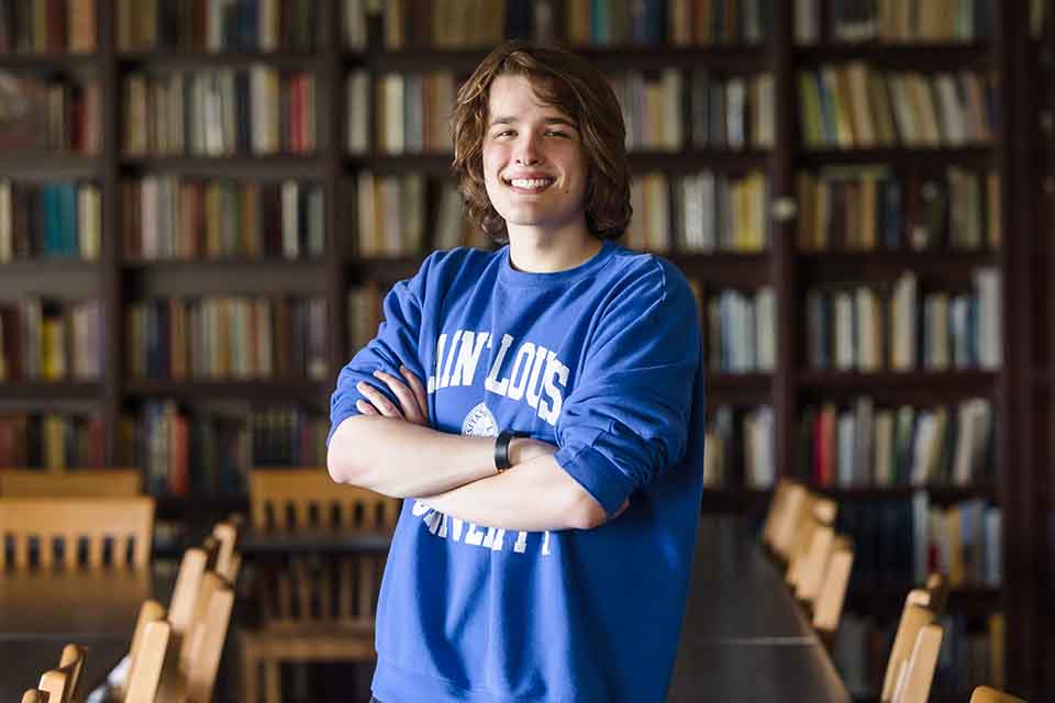 Sam Huster poses for a photo in the library.