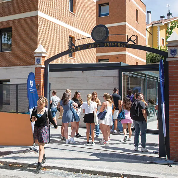 SLU students stand and mingle near the gateway of the SLU-Madrid campus.