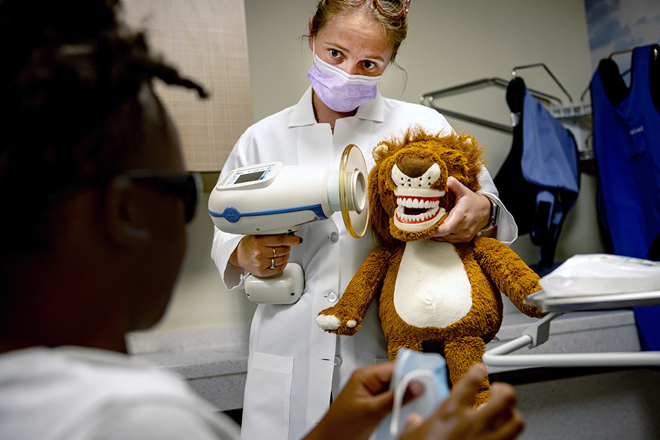 Resident Katelyn Glaenzer models a dental examine on a stuffed lion.