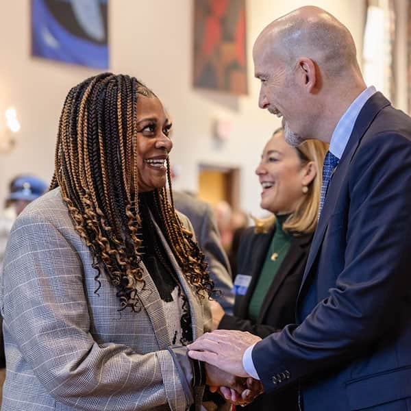 Edward J. Feser, Ph.D. greets a member of the SLU community during a reception in SLU's Saint Louis Room