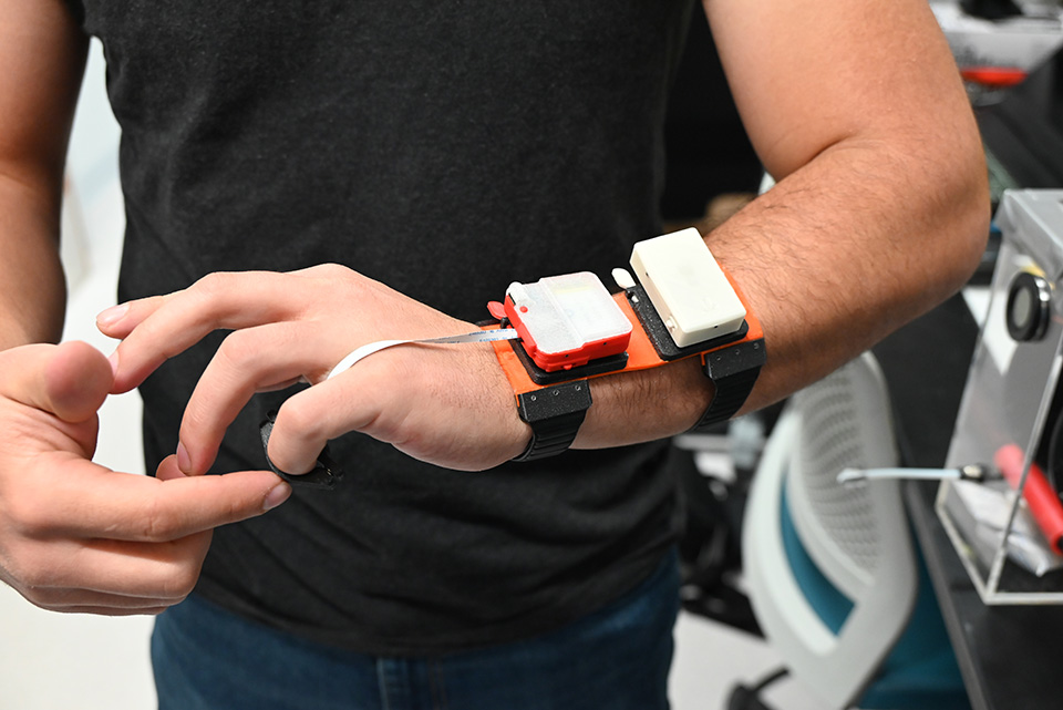 Nicolas Prudencio demonstrates a new device in the CHROME Lab.